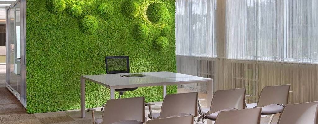Office workers enjoying quiet space with installed acoustic moss wall panels for soundproofing