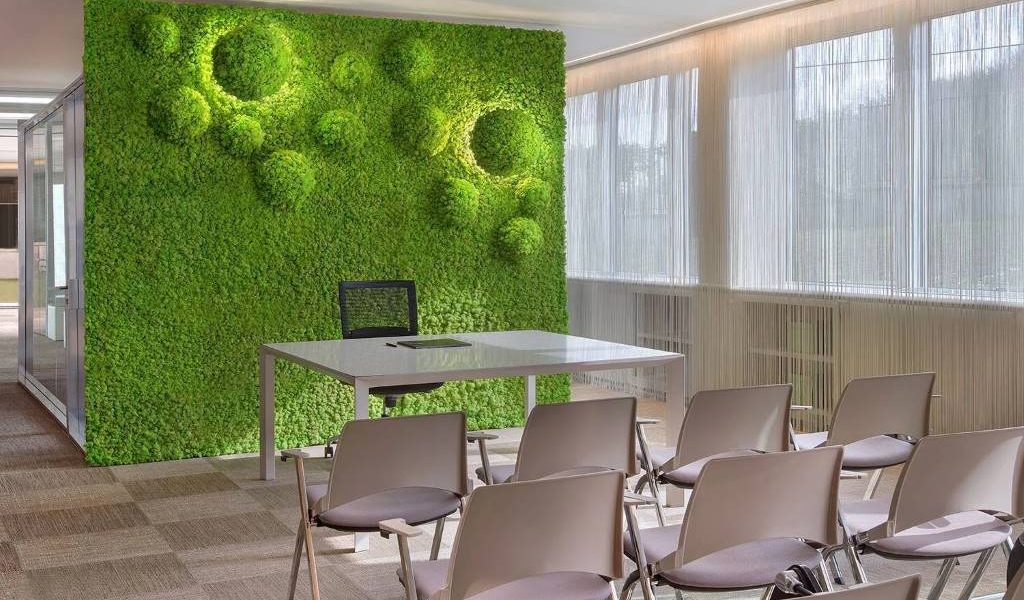 Office workers enjoying quiet space with installed acoustic moss wall panels for soundproofing