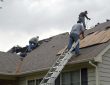 Roof contractors repairing hail damage quickly on a residential roof near me