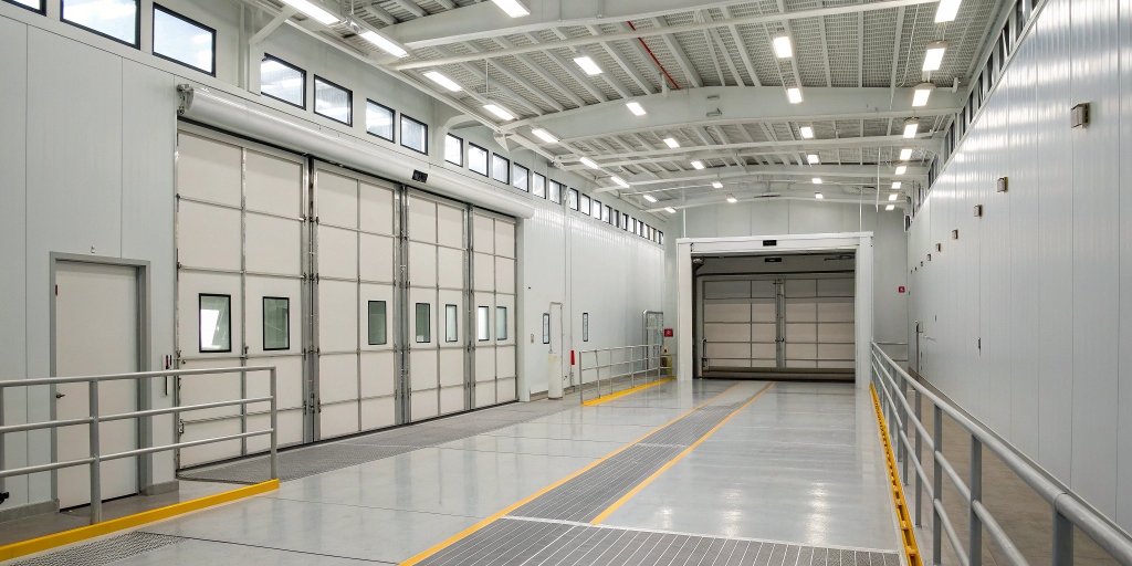 A spacious 120-foot-wide industrial paint booth designed for coating large railings and panels, showcasing its size and suitability for heavy-duty painting projects.
