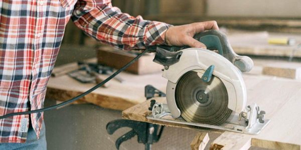Close-up of a 5 1 2 inch circular saw mid-cut on plywood, showcasing clean edges and compact design for home DIY.