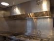 Commercial kitchen hood fire suppression system with visible control panel and fault indicator light